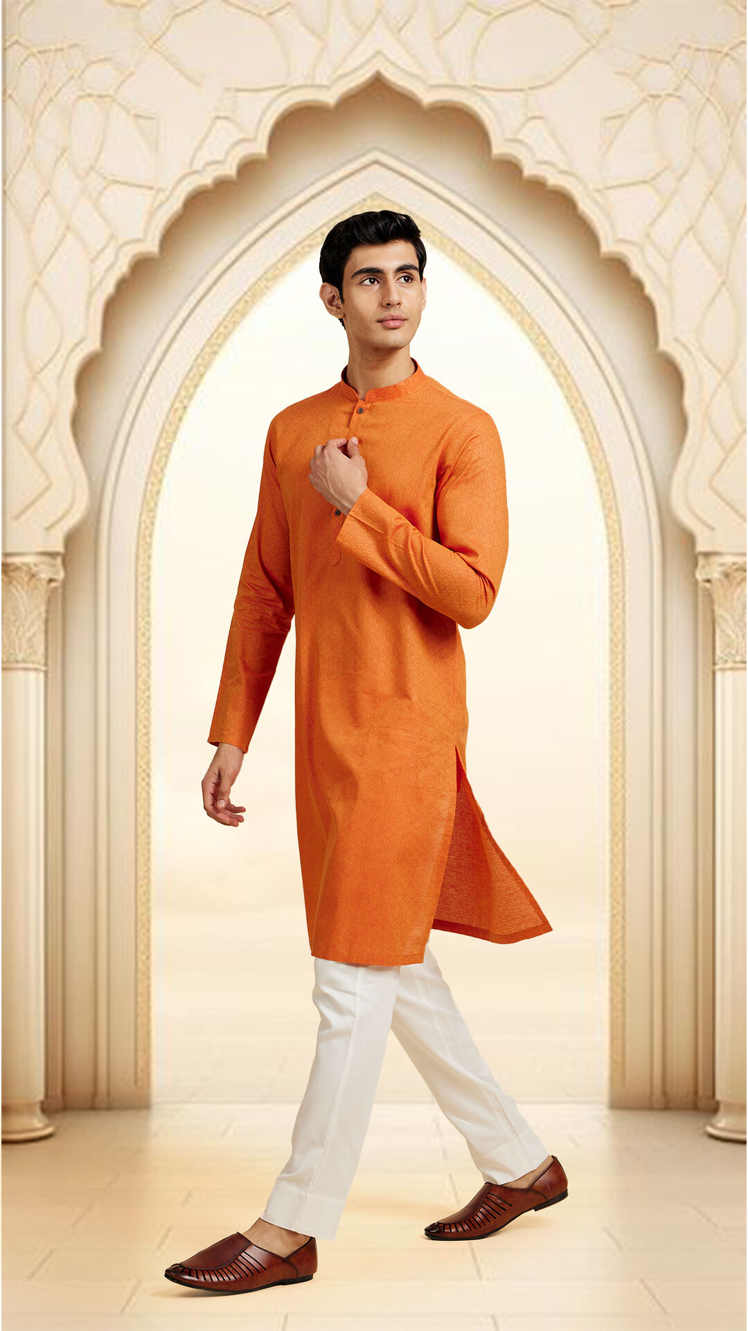 Man walking gracefully in an orange kurta with white pants and traditional footwear, ideal for Ramadan attire